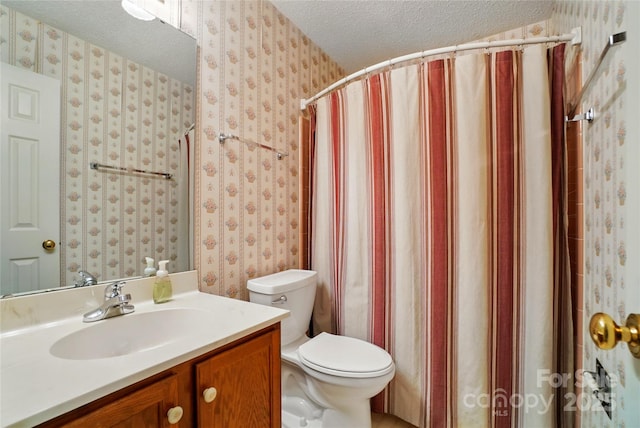 bathroom with a textured ceiling, wallpapered walls, toilet, and vanity