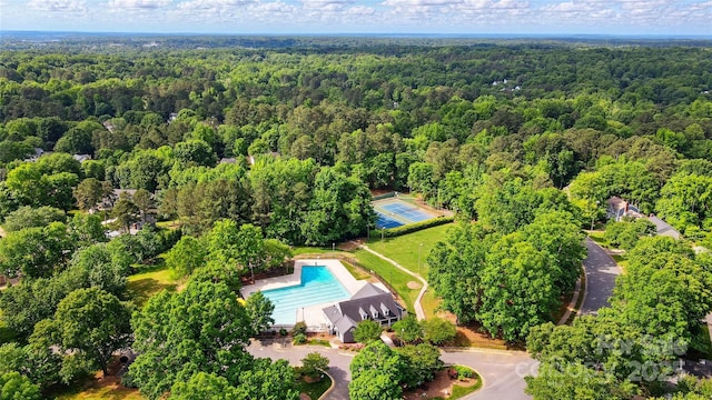 aerial view of a heavily wooded area and a pool