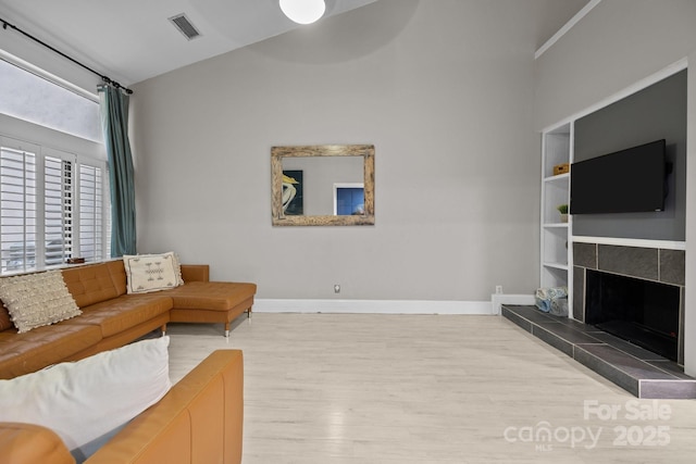 222 Riverview Ter, Clover, SC 29710 - living area with wood finished floors, baseboards, a tiled fireplace, built in shelves, and lofted ceiling
