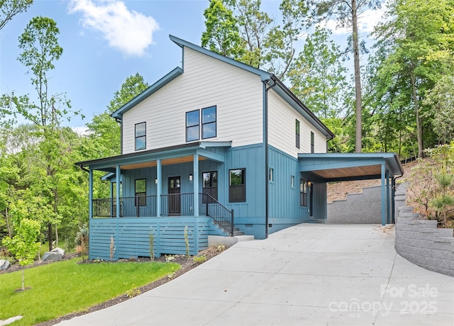 view of front of property featuring board and batten siding, covered porch, concrete driveway, crawl space, and a front lawn