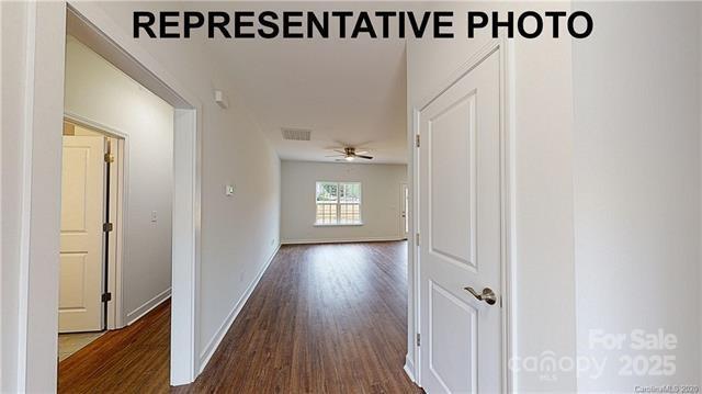 hallway with dark wood finished floors and baseboards