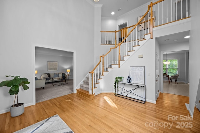 15831 Breton Brook St, Huntersville, NC 28078 - stairway with wood finished floors, baseboards, a towering ceiling, and ornamental molding