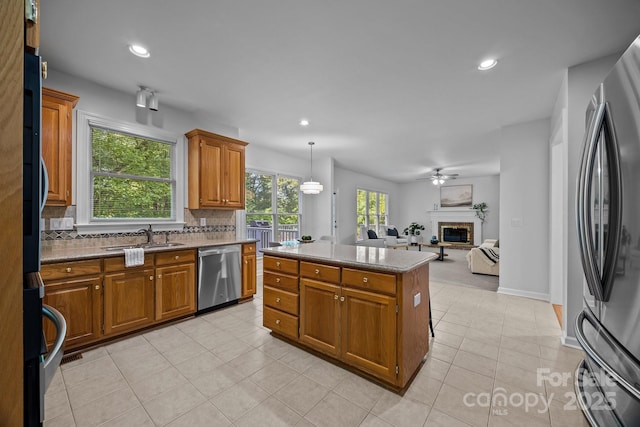 15831 Breton Brook St, Huntersville, NC 28078 - kitchen with stainless steel appliances, a sink, decorative backsplash, brown cabinetry, and recessed lighting