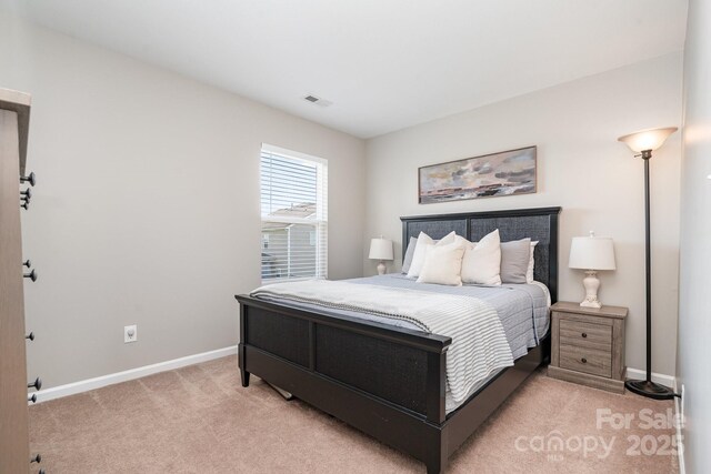 bedroom with light carpet and baseboards