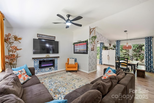 27037 Tidal Way, Tega Cay, SC 29708 - living room featuring wood finished floors, ceiling fan, vaulted ceiling, baseboards, and a glass covered fireplace