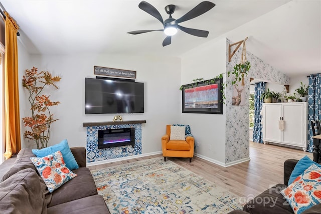 27037 Tidal Way, Tega Cay, SC 29708 - living room featuring vaulted ceiling, wood finished floors, a glass covered fireplace, ceiling fan, and baseboards