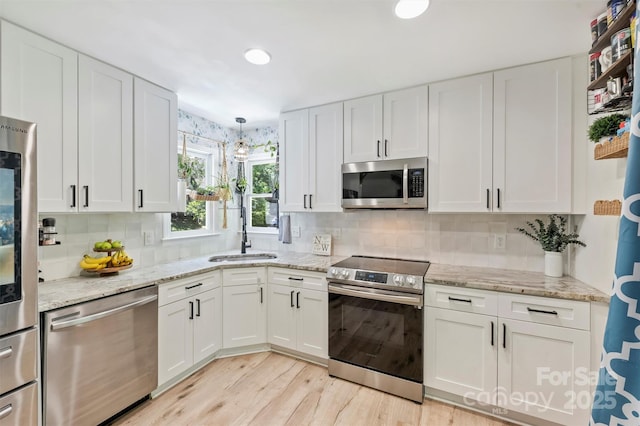27037 Tidal Way, Tega Cay, SC 29708 - kitchen with appliances with stainless steel finishes, a sink, white cabinetry, light wood-type flooring, and recessed lighting