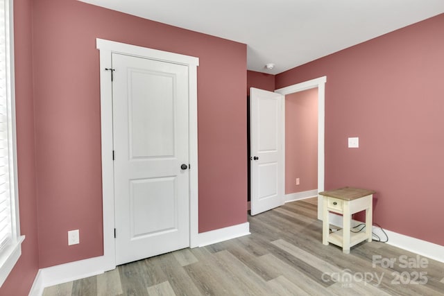 unfurnished bedroom featuring wood finished floors and baseboards