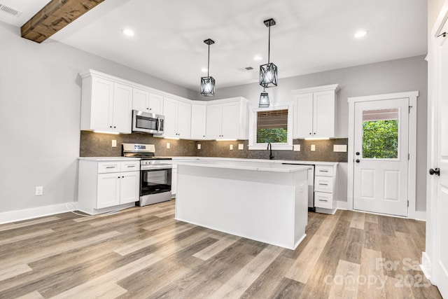 1222 Summerhill St SW, Lenoir, NC 28645 - kitchen with appliances with stainless steel finishes, light wood-style flooring, decorative backsplash, white cabinetry, and recessed lighting