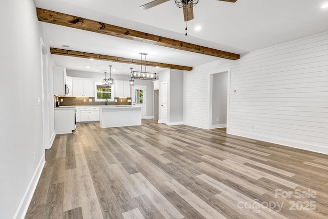 1222 Summerhill St SW, Lenoir, NC 28645 - unfurnished living room featuring ceiling fan, light wood finished floors, beamed ceiling, and recessed lighting
