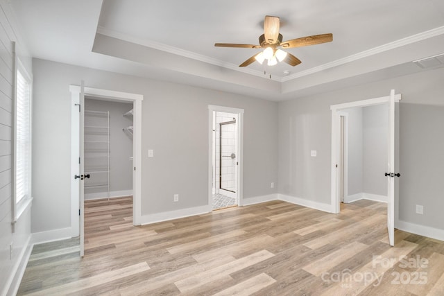 1222 Summerhill St SW, Lenoir, NC 28645 - unfurnished bedroom with a spacious closet, light wood-style floors, ornamental molding, connected bathroom, and a raised ceiling