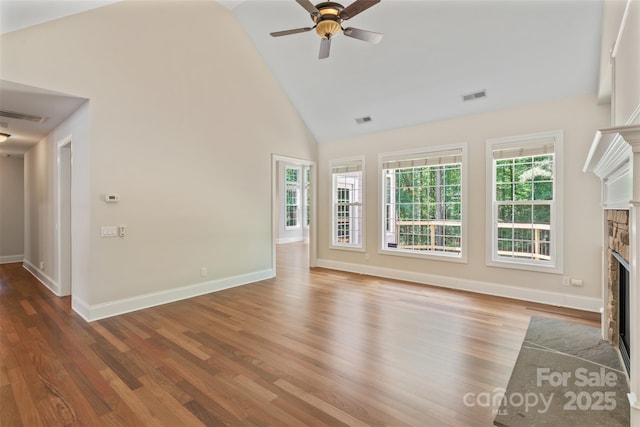 104 Whiterock Dr, Mount Holly, NC 28120 - unfurnished living room with a stone fireplace, ceiling fan, high vaulted ceiling, wood finished floors, and baseboards