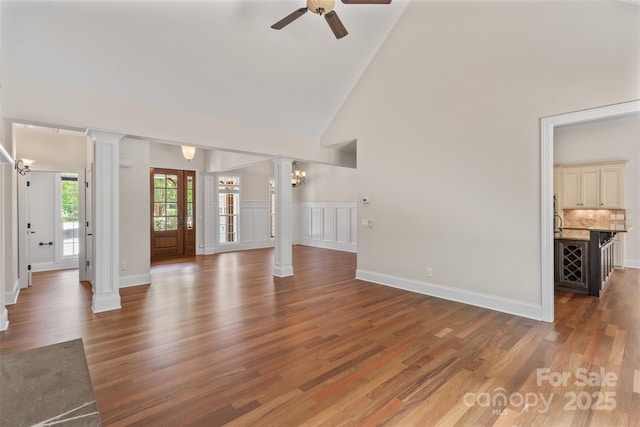 104 Whiterock Dr, Mount Holly, NC 28120 - unfurnished living room with ornate columns, high vaulted ceiling, a ceiling fan, wood finished floors, and baseboards