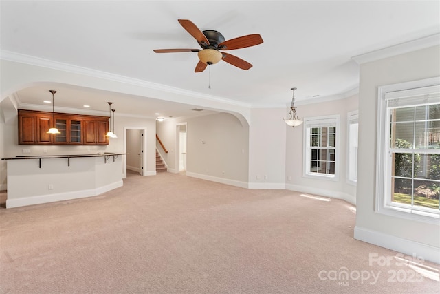 104 Whiterock Dr, Mount Holly, NC 28120 - unfurnished living room featuring arched walkways, light carpet, baseboards, crown molding, and a ceiling fan