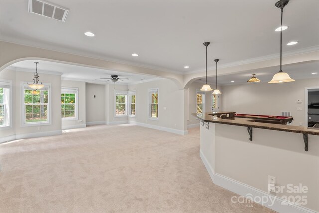 104 Whiterock Dr, Mount Holly, NC 28120 - kitchen with arched walkways, crown molding, baseboards, light colored carpet, and a kitchen breakfast bar