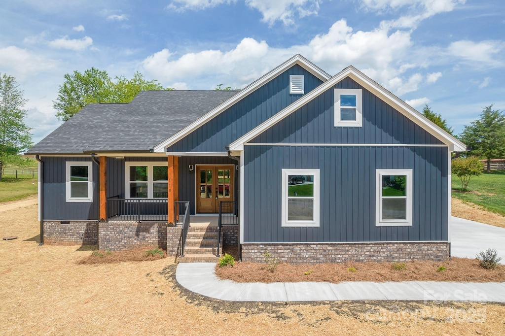 view of front of property with a porch, a shingled roof, and board and batten siding