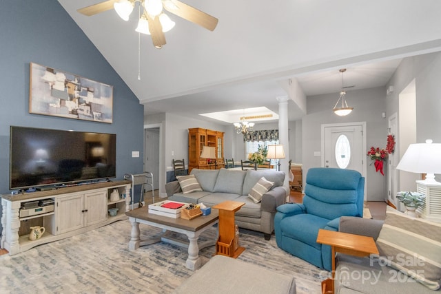 living room featuring a chandelier, a ceiling fan, and high vaulted ceiling
