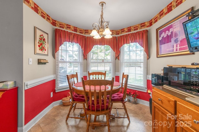 dining room with a chandelier, plenty of natural light, and baseboards