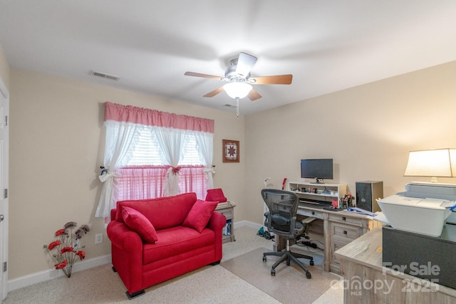 carpeted office space with ceiling fan and baseboards
