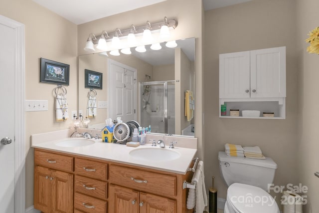 bathroom with toilet, a stall shower, and double vanity