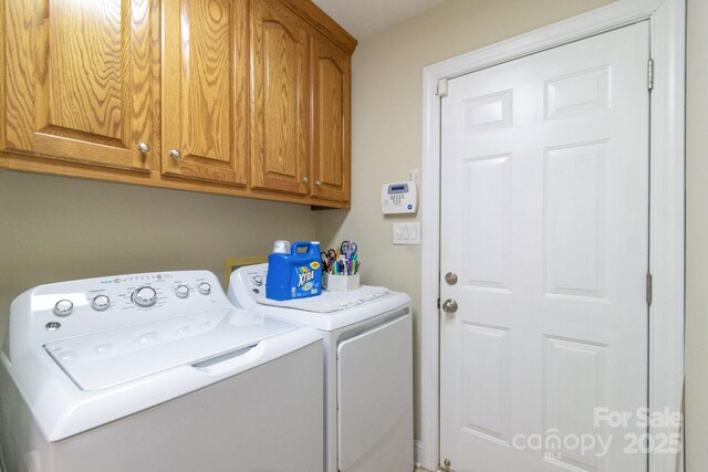 clothes washing area with cabinet space and washing machine and clothes dryer