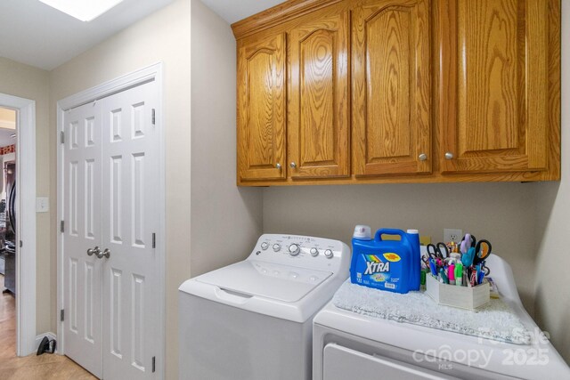 laundry area with washer and clothes dryer and cabinet space