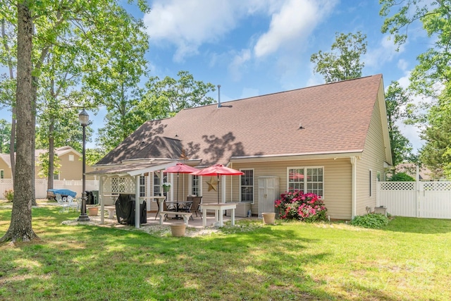 rear view of property with a patio and roof with shingles