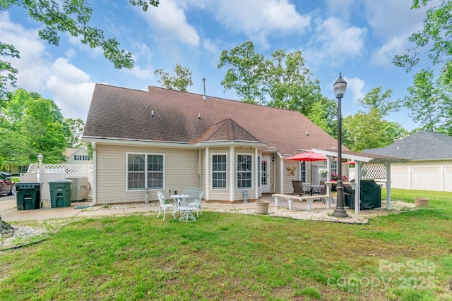 rear view of house featuring a patio, central AC unit, and roof with shingles