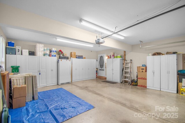 garage with freestanding refrigerator and a garage door opener