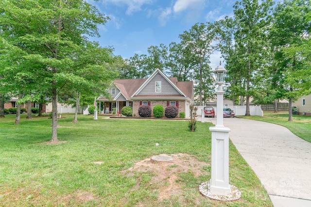 view of front of house featuring driveway, covered porch, and brick siding