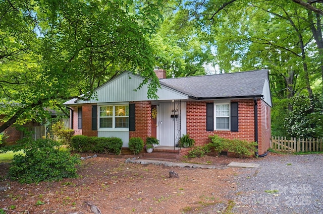 4647 General Pershing Dr, Charlotte, NC 28209 - view of front of house featuring fence, a chimney, brick siding, and roof with shingles