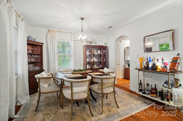 4647 General Pershing Dr, Charlotte, NC 28209 - dining room featuring wood finished floors, arched walkways, and a chandelier