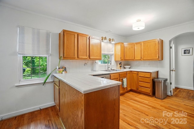 4647 General Pershing Dr, Charlotte, NC 28209 - kitchen with a sink, arched walkways, a peninsula, light wood-style flooring, and tasteful backsplash
