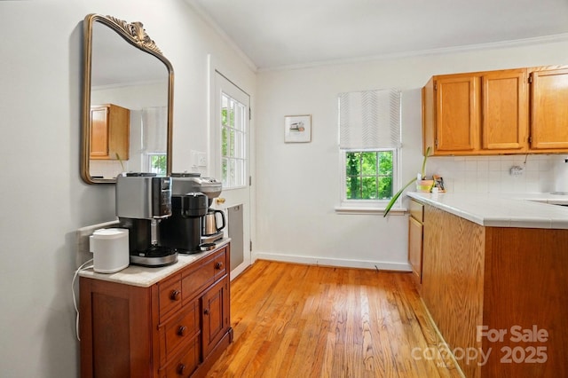 4647 General Pershing Dr, Charlotte, NC 28209 - kitchen with crown molding, light wood-type flooring, brown cabinets, backsplash, and baseboards