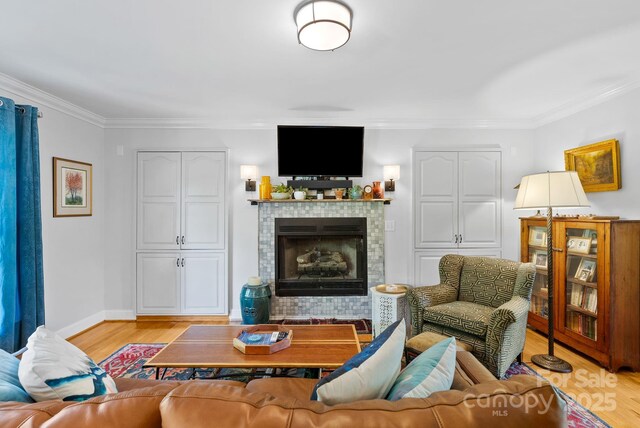 50 Pinerose Dr, Weaverville, NC 28787 - living area featuring a tiled fireplace, light wood-style flooring, ornamental molding, and baseboards