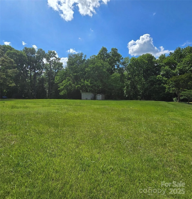 6573 Weldon Cir NW Unit 22, Concord, NC 28027 - view of green lawn featuring a wooded view