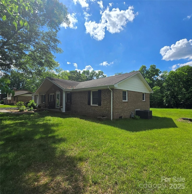 6573 Weldon Cir NW Unit 22, Concord, NC 28027 - view of side of home with brick siding, central AC, and a yard