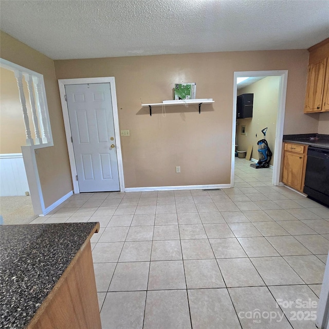 6573 Weldon Cir NW Unit 22, Concord, NC 28027 - kitchen with black dishwasher, dark countertops, light tile patterned floors, a textured ceiling, and baseboards