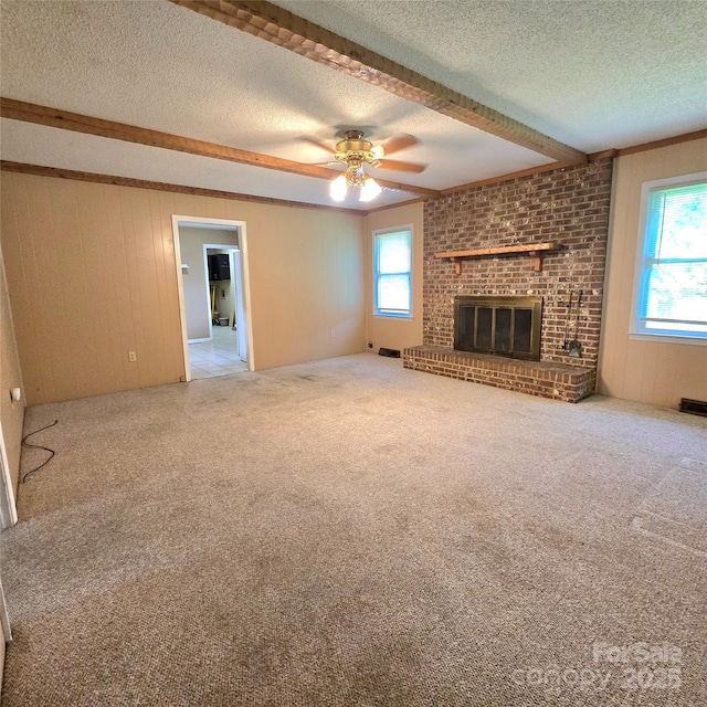 6573 Weldon Cir NW Unit 22, Concord, NC 28027 - unfurnished living room featuring beam ceiling, a textured ceiling, ceiling fan, healthy amount of natural light, and a brick fireplace