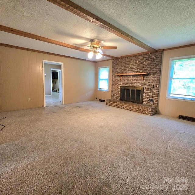 6573 Weldon Cir NW Unit 22, Concord, NC 28027 - unfurnished living room featuring beam ceiling, a textured ceiling, a fireplace, a ceiling fan, and carpet flooring