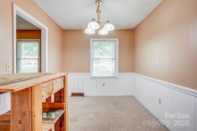 6573 Weldon Cir NW Unit 22, Concord, NC 28027 - unfurnished dining area with wainscoting, plenty of natural light, a chandelier, and carpet