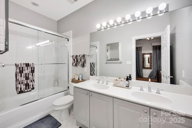 bathroom featuring double vanity, bath / shower combo with glass door, and toilet