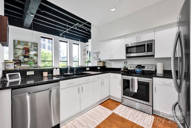 kitchen featuring stainless steel appliances, a sink, light wood-type flooring, white cabinetry, and recessed lighting