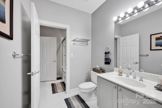 bathroom with toilet, vanity, enclosed tub / shower combo, and tile patterned floors