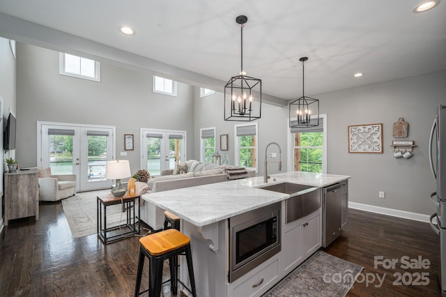 kitchen with appliances with stainless steel finishes, a sink, french doors, open floor plan, and recessed lighting