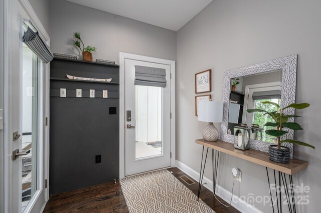 doorway to outside featuring dark wood finished floors and baseboards