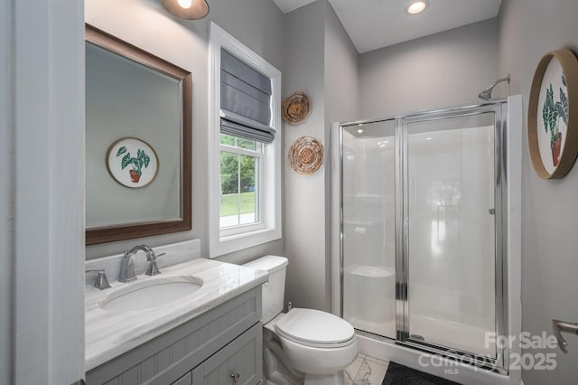 bathroom featuring a stall shower, vanity, toilet, and recessed lighting