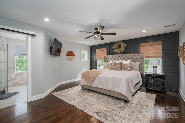 bedroom with a barn door, dark wood-type flooring, baseboards, recessed lighting, and ceiling fan
