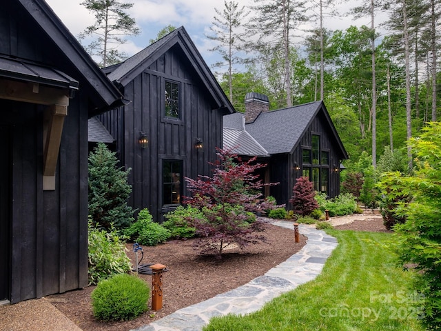 276 Stone Field Trl, Brevard, NC 28712 - view of home's exterior with board and batten siding, a chimney, and roof with shingles