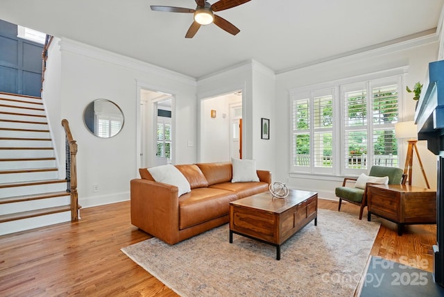 15714 Laurel Oak Cres, Davidson, NC 28036 - living room featuring stairway, ceiling fan, light wood-style flooring, healthy amount of natural light, and ornamental molding